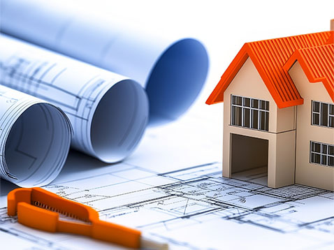 Architectural Engineering Blueprint rolled up alongside a marker and miniature house